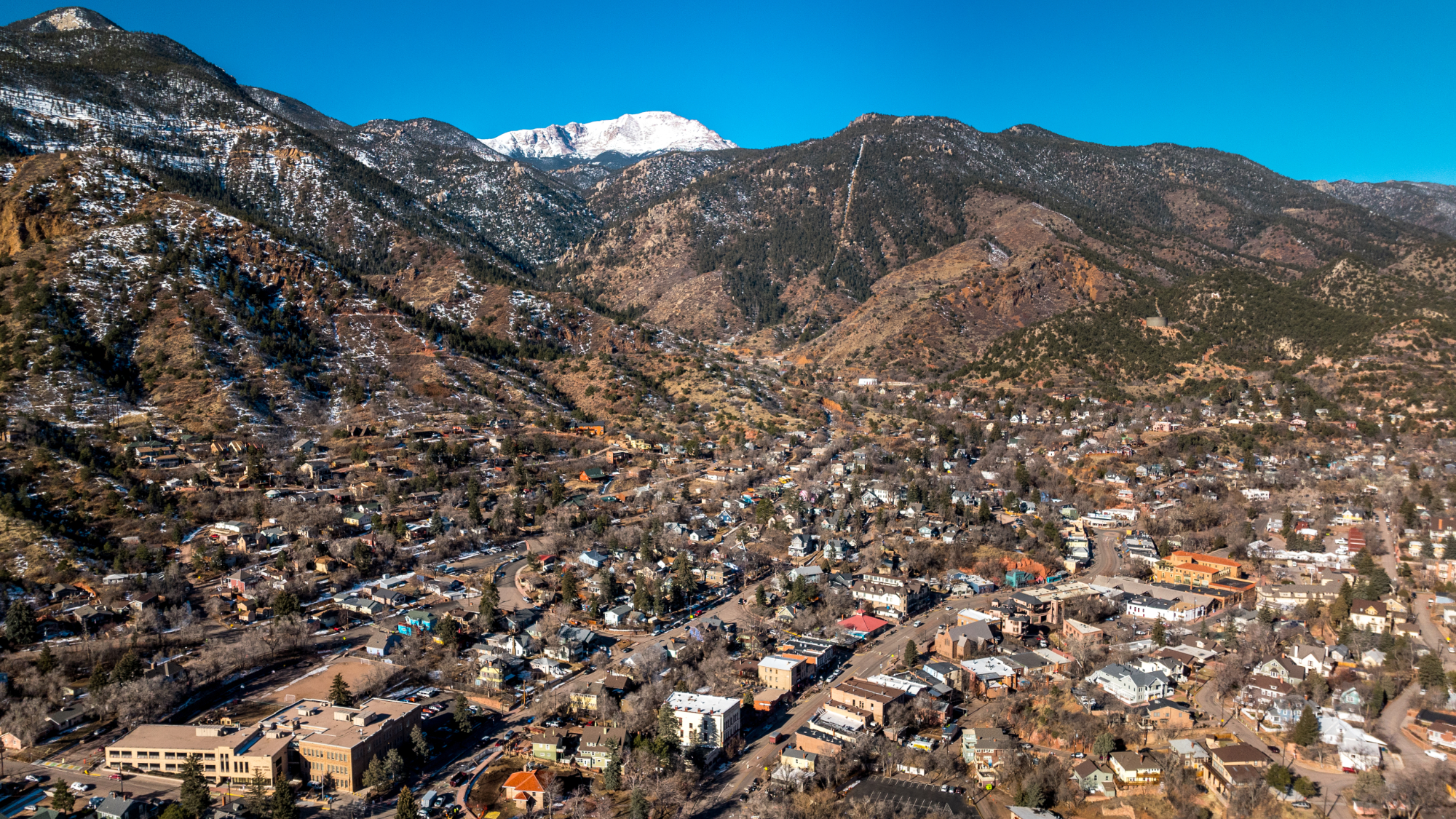 Aerial shot of Manitou Springs with snow-dusted mountains rising nearby in Colorado.